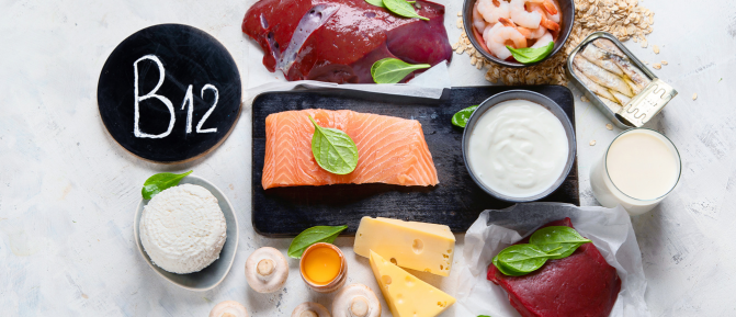 Alimenti ricchi di vitamina B12 come salmone, carne, fegato, uova, latticini e pesce, disposti su un piano chiaro, a supporto di energia, metabolismo e sistema nervoso.