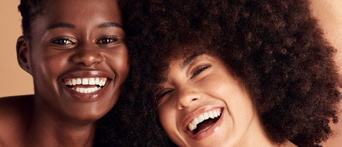 Donne di età diverse sorridono abbracciate, immagine che rappresenta benessere, inclusione e attenzione alla salute femminile in ogni fase della vita.