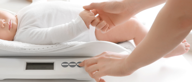 Neonato sulla bilancia per essere pesato