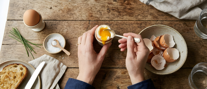 Uova e alimenti proteici su un tavolo, immagine dedicata all’importanza delle proteine per massa muscolare, forza e benessere a ogni età.