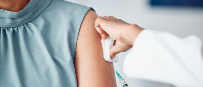 Operatore sanitario mentre somministra al braccio di una persona, a rappresentare il servizio di vaccini disponibile in Farmacia